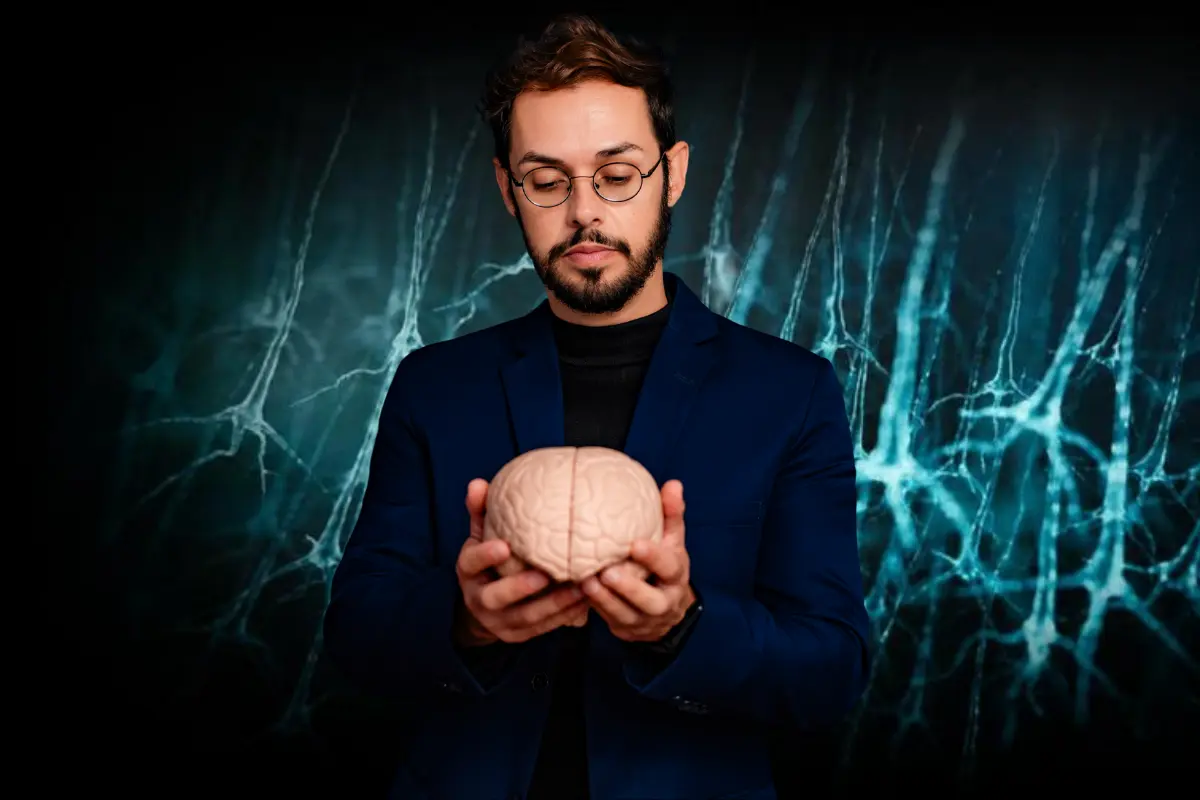 Homem de óculos e paletó azul segurando modelo de cérebro humano em curso de neurociência e córtex.